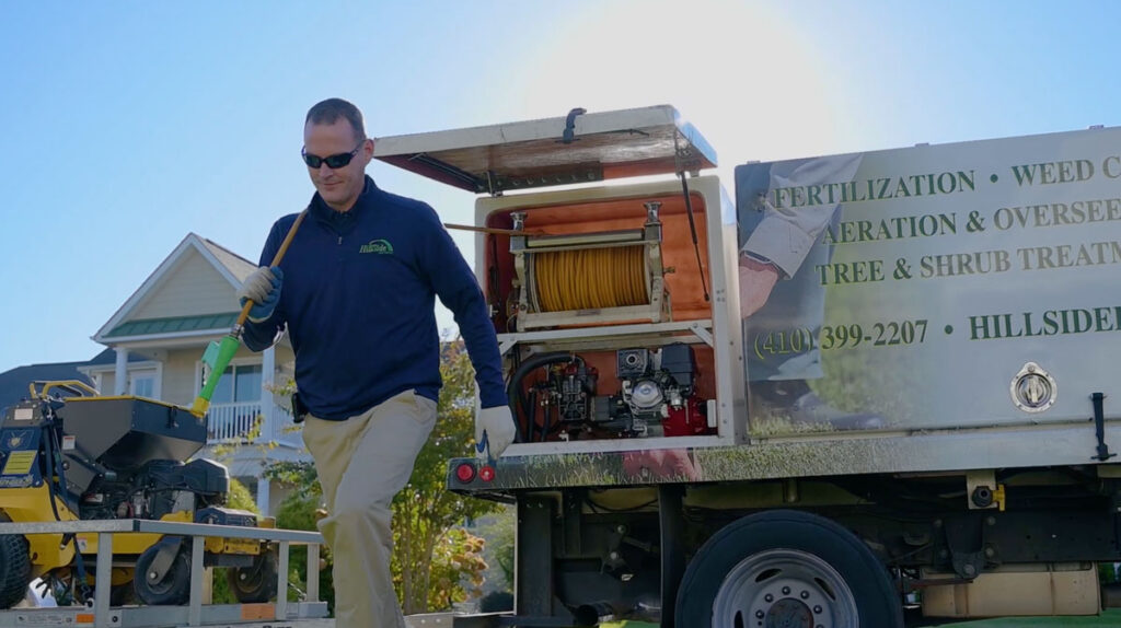 tech walking from truck with hose
