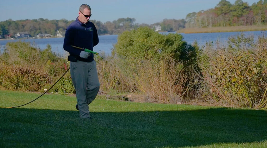 tech spraying for insects near waterfront home